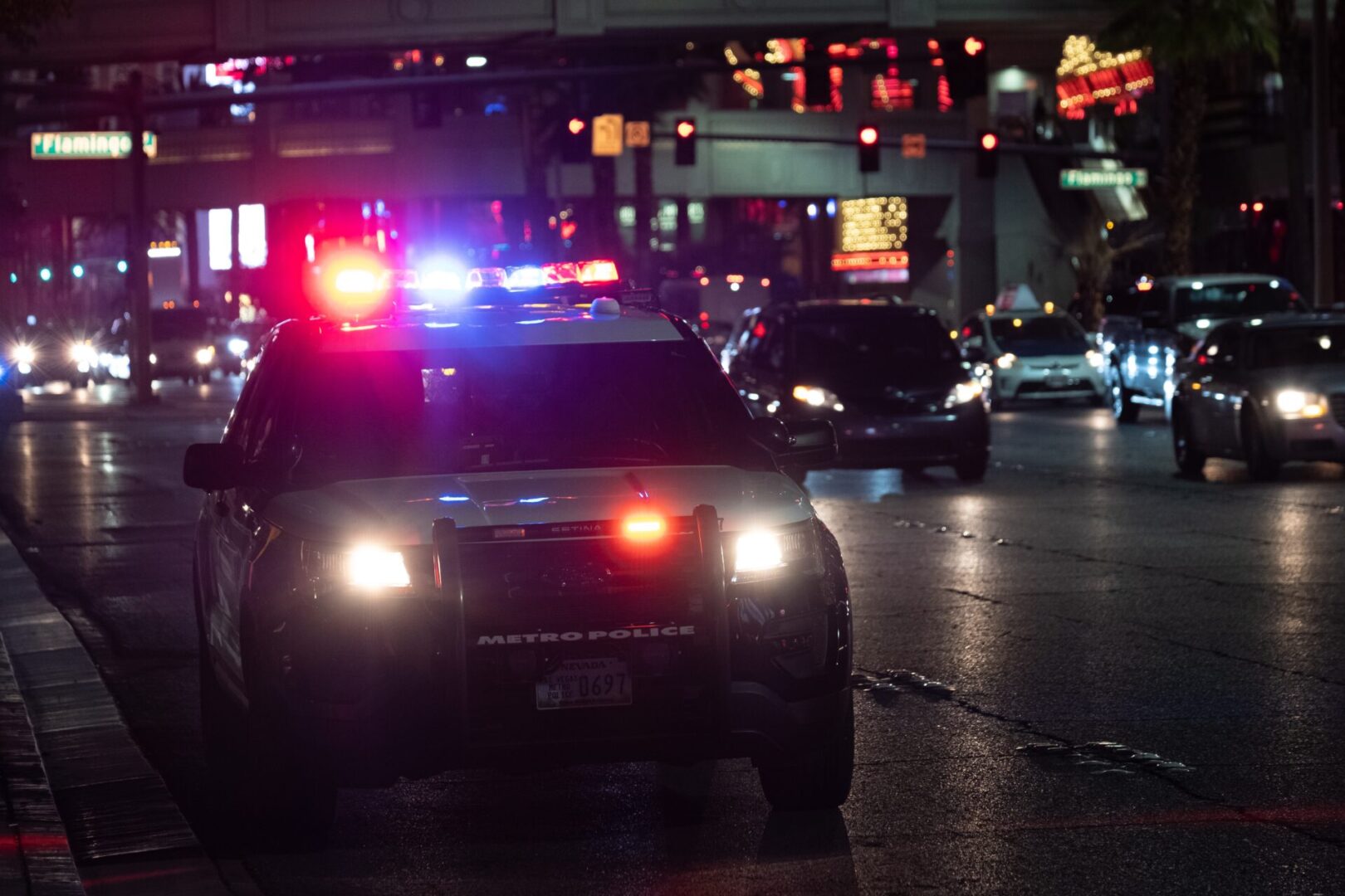 A police car is stopped at an intersection.