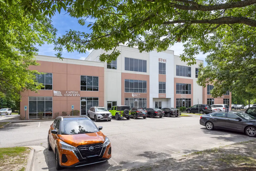 A parking lot with cars parked in front of it.