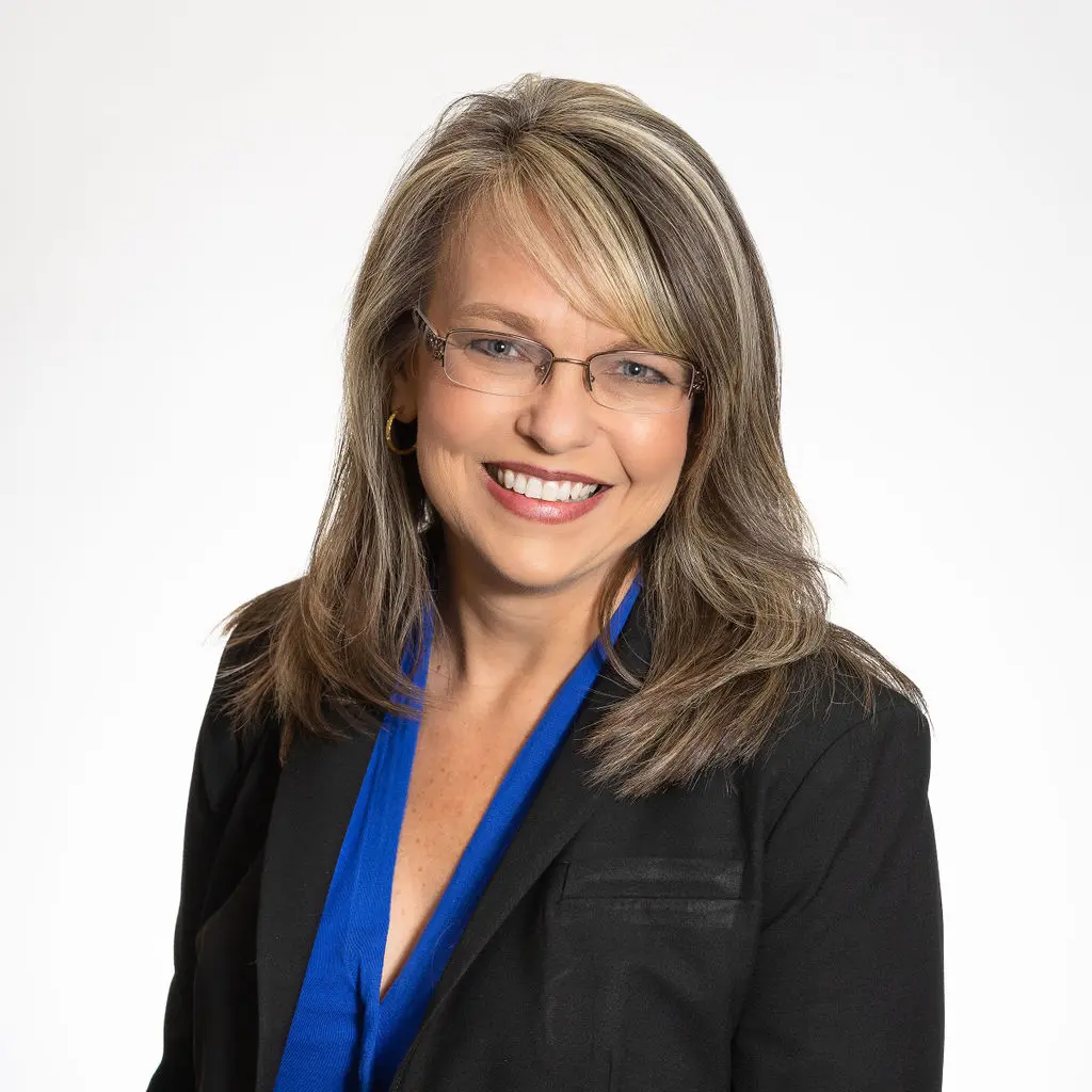 A woman in a black jacket and blue shirt